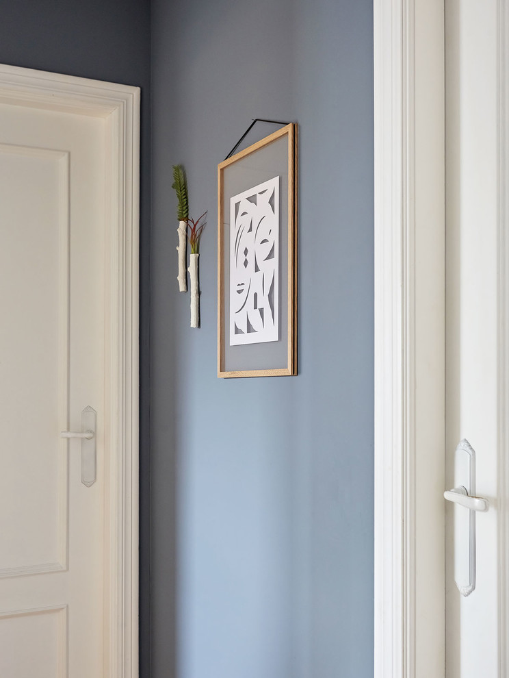 Ispirazione per un piccolo ingresso o corridoio nordico con pareti blu, pavimento in legno massello medio e pavimento marrone