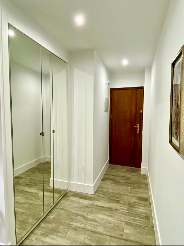 Réalisation d'un couloir design de taille moyenne avec un mur blanc, un sol en carrelage de porcelaine et un sol beige.