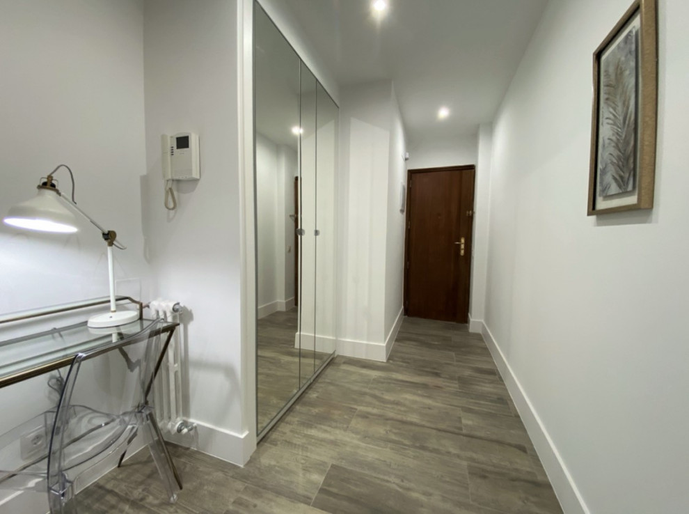 Idée de décoration pour un couloir design de taille moyenne avec un mur blanc, un sol en carrelage de porcelaine et un sol beige.