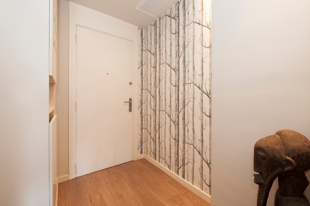 Foto de recibidores y pasillos tropicales pequeños con paredes grises, suelo de madera en tonos medios y suelo marrón