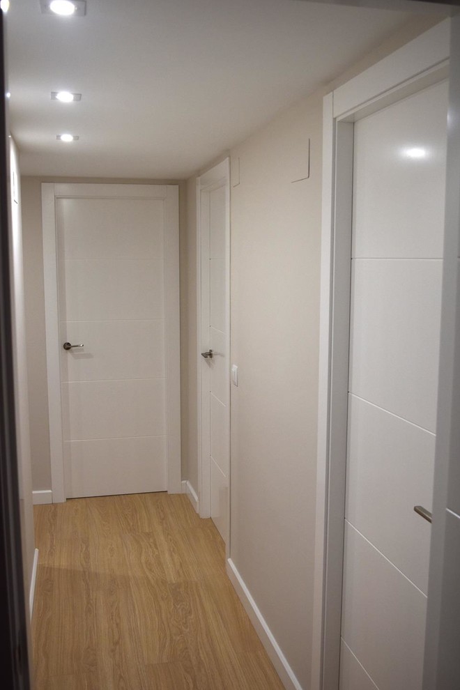 Idee per un ingresso o corridoio moderno di medie dimensioni con pareti bianche, pavimento in legno massello medio e pavimento marrone