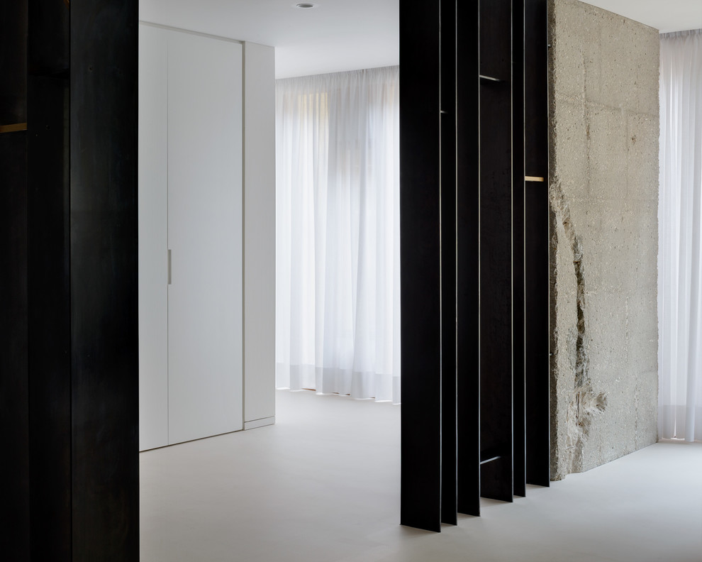 Immagine di un ingresso o corridoio minimalista con pareti bianche, pavimento in cemento e pavimento bianco