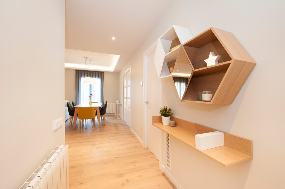 Ejemplo de recibidores y pasillos minimalistas de tamaño medio con paredes blancas, suelo de madera en tonos medios y suelo marrón