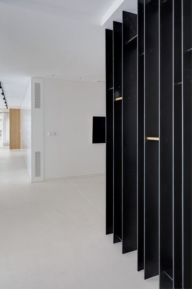 Esempio di un ingresso o corridoio minimalista con pareti bianche, pavimento in cemento e pavimento bianco