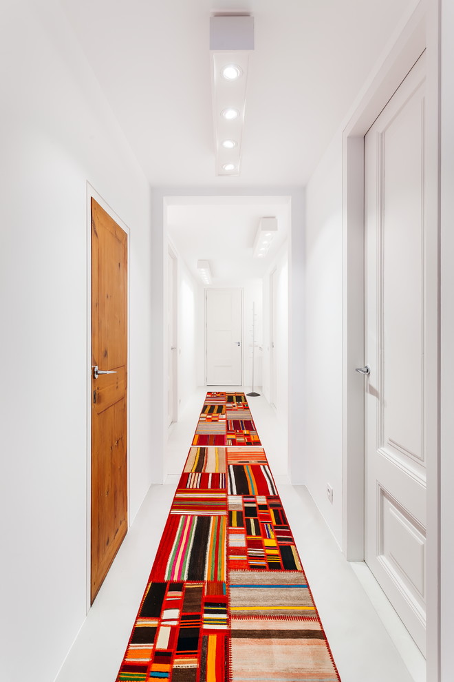 Réalisation d'un couloir design de taille moyenne avec un mur blanc, sol en béton ciré et un sol gris.
