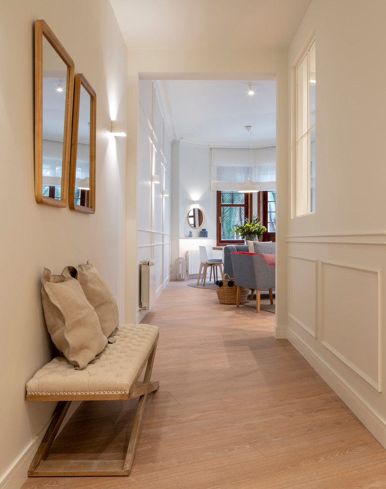 Esempio di un ingresso o corridoio minimal di medie dimensioni con pareti bianche, pavimento in laminato e pavimento marrone