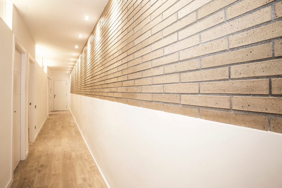 Idées déco pour un couloir industriel de taille moyenne avec un mur beige et un sol en bois brun.