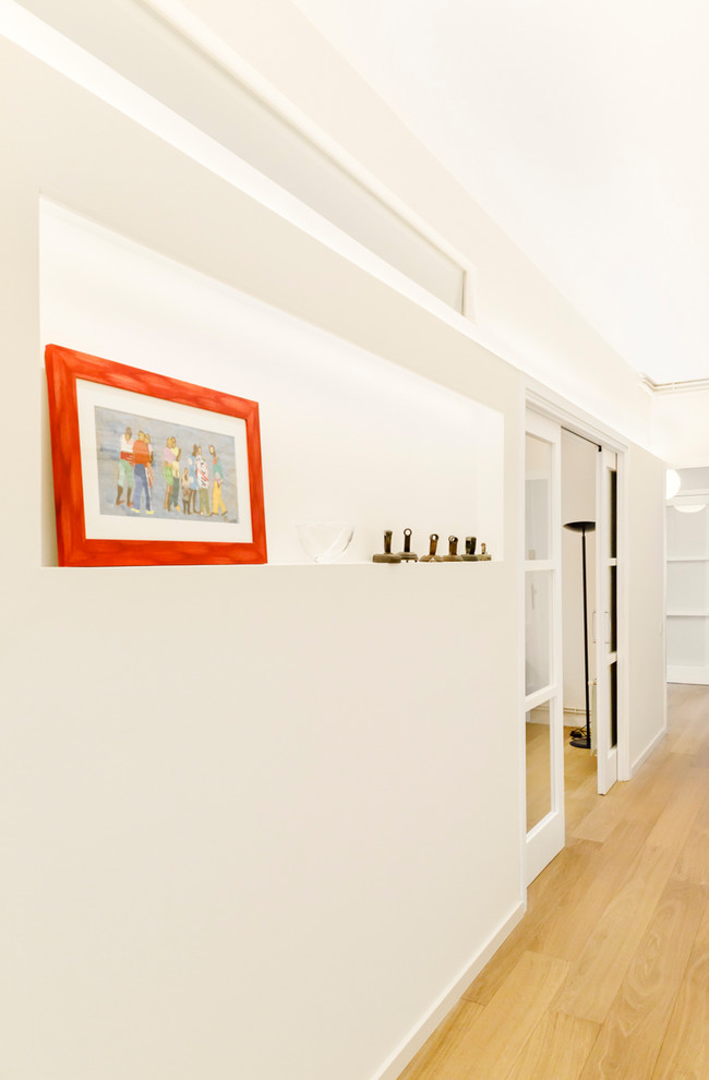 Inspiration pour un couloir design avec un mur blanc, un sol en bois brun et un sol marron.