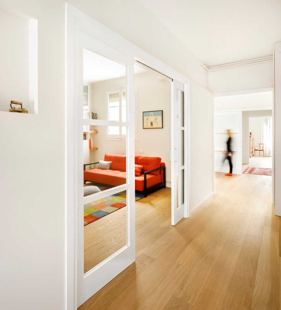 Diseño de recibidores y pasillos contemporáneos con paredes blancas, suelo de madera en tonos medios y suelo marrón