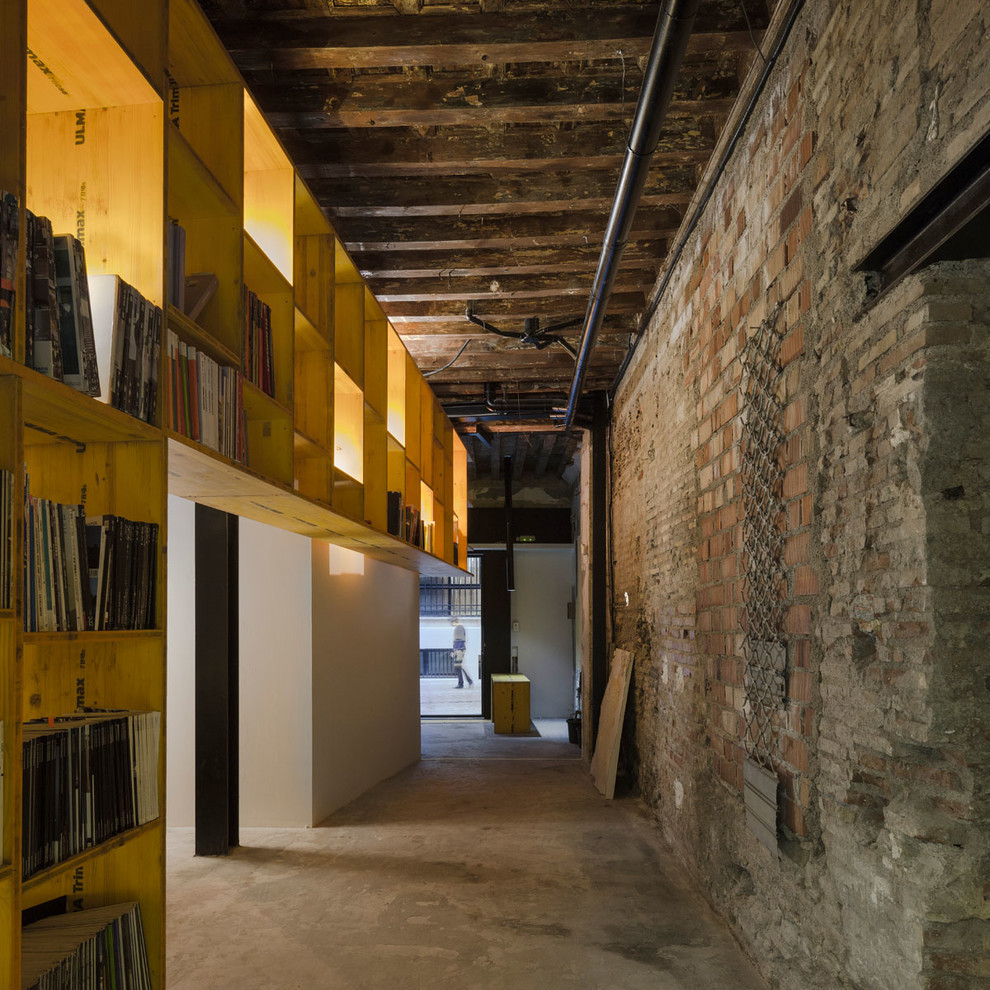 На фото: большой коридор в стиле лофт с коричневыми стенами, бетонным полом и серым полом с
