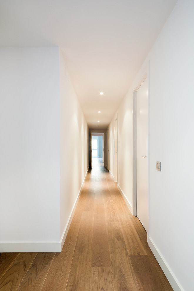 Idee per un ingresso o corridoio mediterraneo di medie dimensioni con pareti bianche e pavimento in legno massello medio