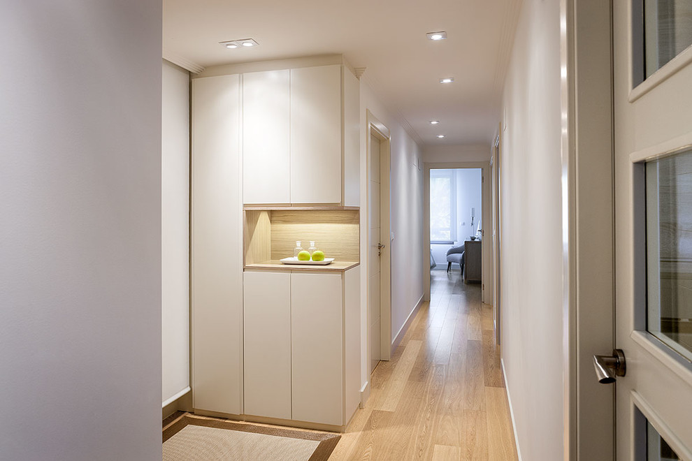 Imagen de recibidores y pasillos minimalistas pequeños con paredes blancas y suelo de madera clara