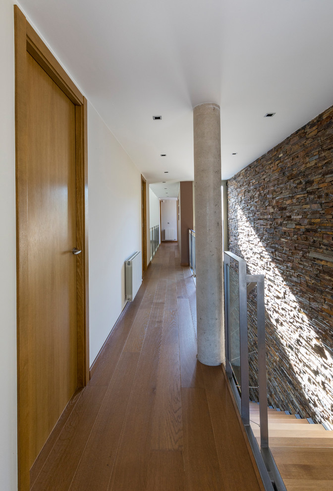 他の地域にあるコンテンポラリースタイルのおしゃれな廊下 (ベージュの壁、無垢フローリング、茶色い床) の写真