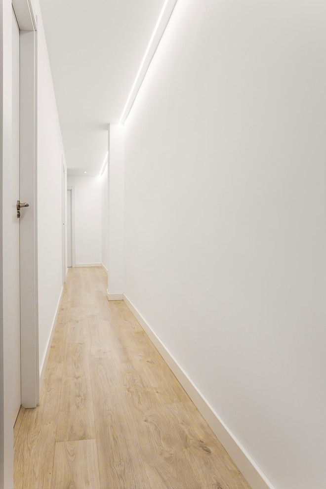 Diseño de recibidores y pasillos escandinavos con paredes blancas, suelo de madera clara y suelo beige