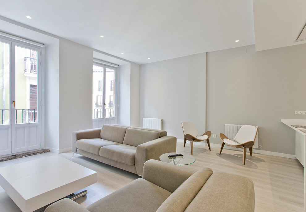 Aménagement d'une salle de séjour contemporaine de taille moyenne et ouverte avec un mur blanc, parquet clair, aucune cheminée et un sol beige.