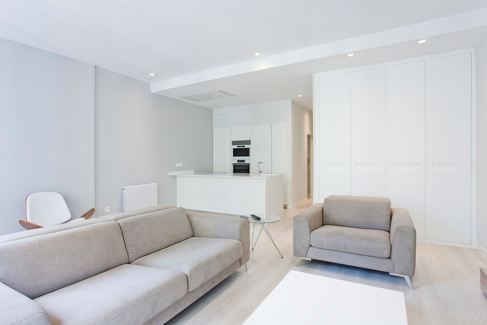 Cette photo montre une salle de séjour tendance de taille moyenne et ouverte avec un mur blanc, parquet clair, aucune cheminée et un sol beige.