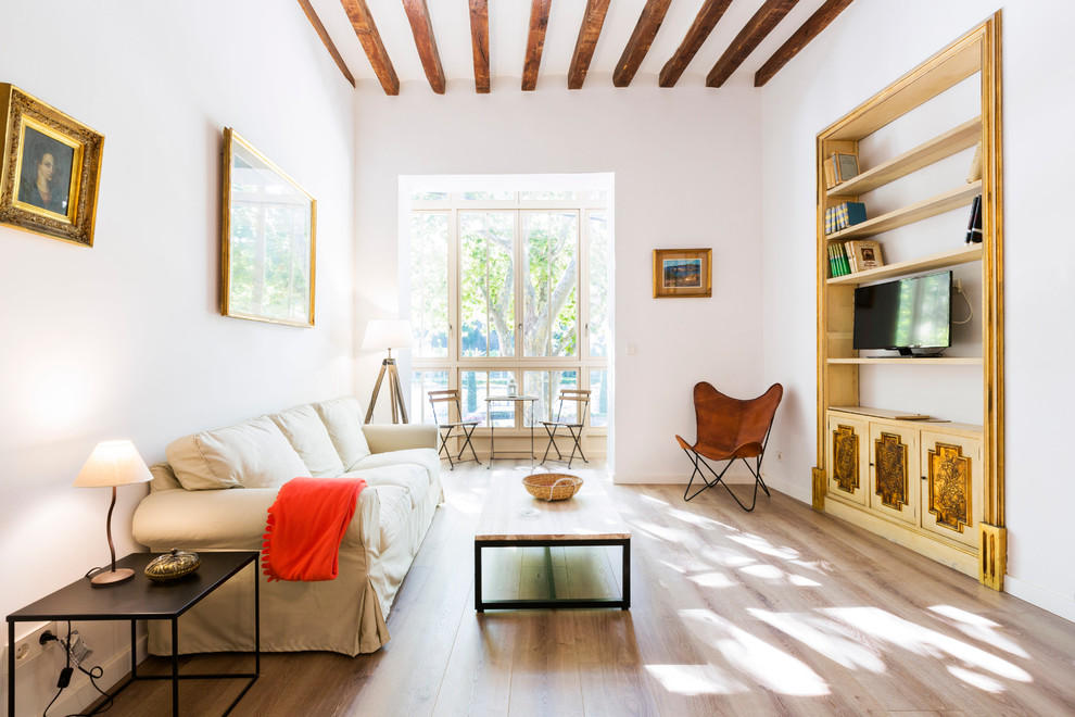 Mittelgroßes, Offenes Eklektisches Wohnzimmer ohne Kamin mit weißer Wandfarbe, hellem Holzboden und freistehendem TV in Palma de Mallorca