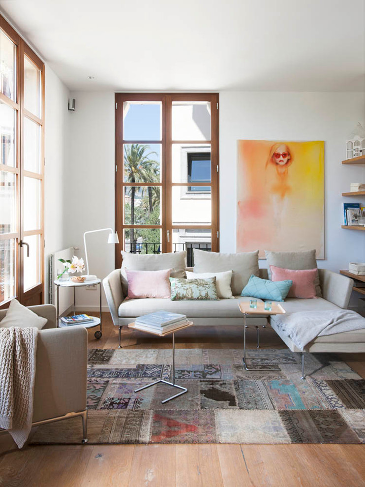 Imagen de sala de estar con biblioteca abierta escandinava de tamaño medio sin chimenea y televisor con paredes blancas y suelo de madera en tonos medios