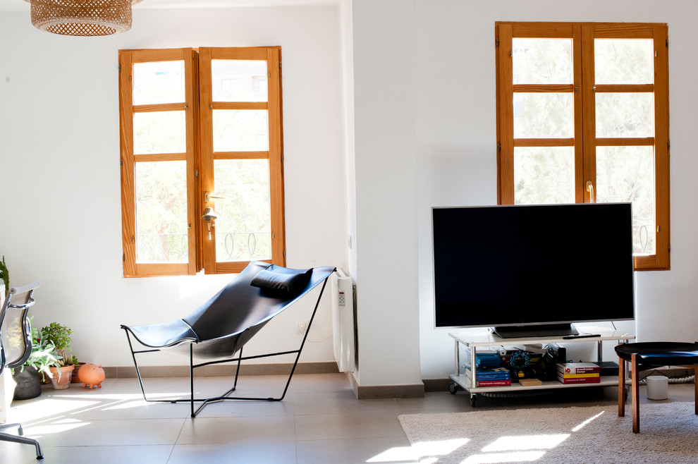 Cette image montre une salle de séjour design ouverte avec salle de jeu, un mur blanc, un sol en carrelage de céramique, un téléviseur d'angle et un sol beige.