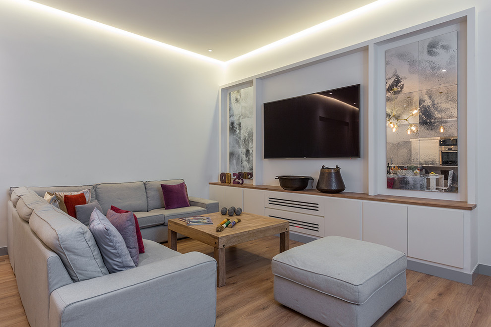 Mittelgroßes Modernes Wohnzimmer ohne Kamin mit braunem Holzboden, TV-Wand und grauer Wandfarbe in Madrid