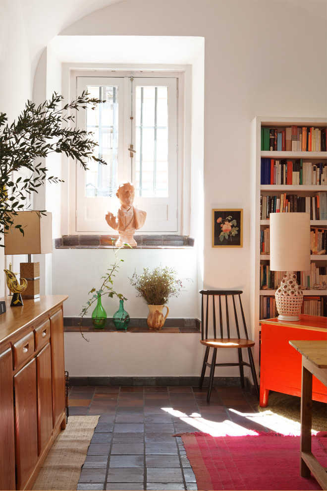 Example of a small tuscan open concept terra-cotta tile family room library design in Madrid with white walls, no fireplace and no tv