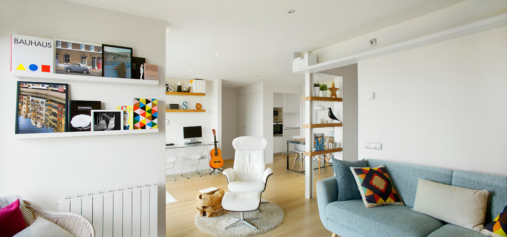 Modelo de sala de estar con biblioteca abierta nórdica de tamaño medio sin chimenea y televisor con paredes blancas y suelo de madera clara