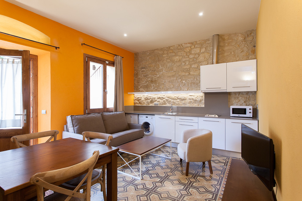 Modelo de sala de estar abierta mediterránea pequeña sin chimenea y televisor con paredes multicolor
