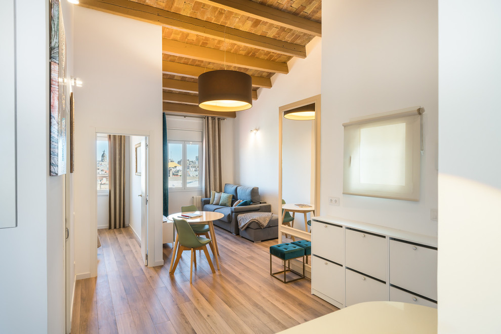 Modelo de sala de estar abierta clásica renovada con suelo de madera en tonos medios y paredes blancas