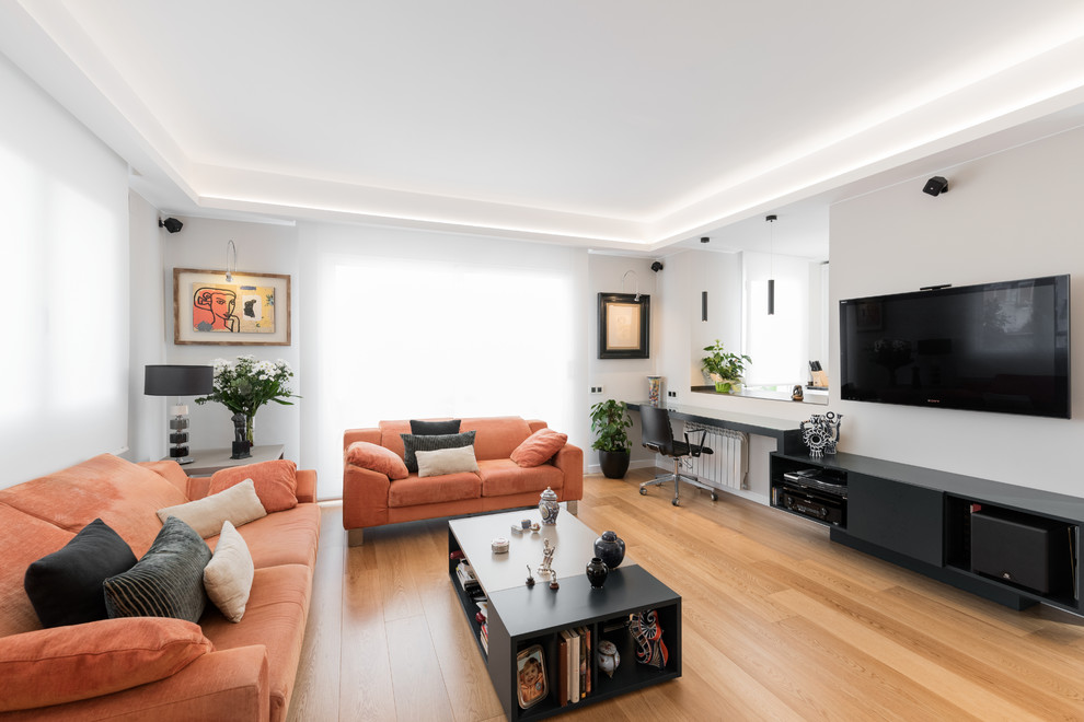 Ejemplo de sala de estar actual con paredes blancas, suelo de madera clara y televisor colgado en la pared