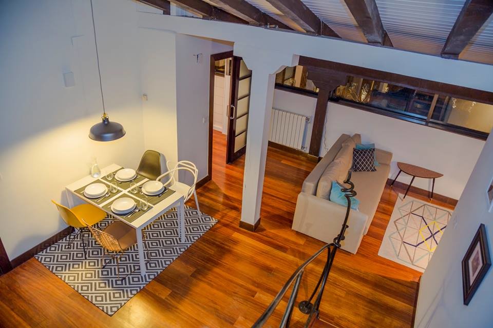Foto de sala de estar abierta escandinava de tamaño medio con paredes blancas, suelo de madera en tonos medios y televisor en una esquina