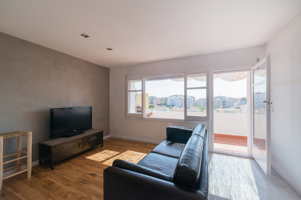 Foto de sala de estar abierta nórdica de tamaño medio sin chimenea con paredes multicolor, suelo de madera en tonos medios y pared multimedia