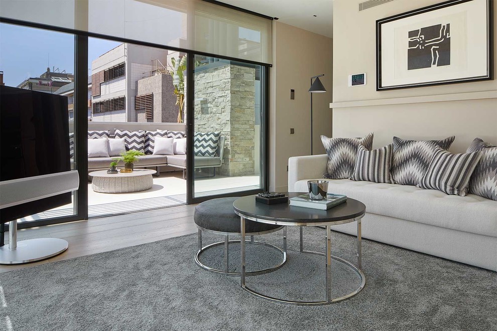 Idée de décoration pour une salle de séjour design de taille moyenne avec un téléviseur indépendant et un mur beige.