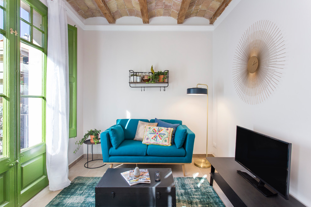 Ejemplo de sala de estar mediterránea pequeña con paredes blancas, televisor independiente y suelo beige
