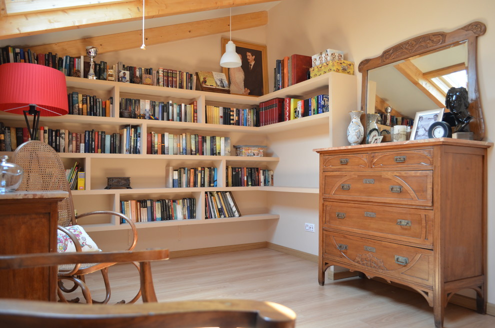 Cette image montre une petite salle de séjour vintage fermée avec une bibliothèque ou un coin lecture, un mur beige, parquet clair, aucune cheminée et aucun téléviseur.