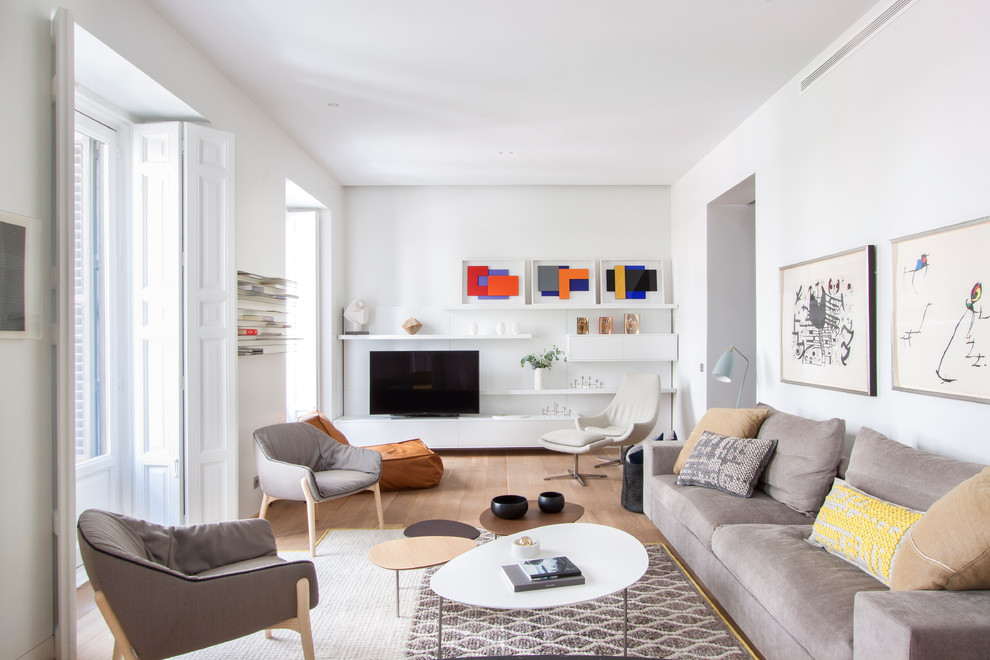 Идея дизайна: большая изолированная гостиная комната в скандинавском стиле с белыми стенами, светлым паркетным полом и отдельно стоящим телевизором без камина