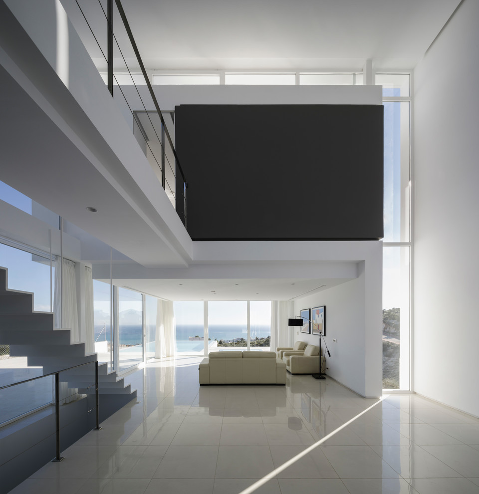 Foto di un grande soggiorno minimalista aperto con pareti bianche, pavimento in gres porcellanato, porta TV ad angolo e pavimento bianco