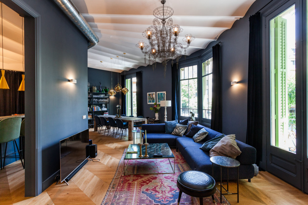Foto di un soggiorno mediterraneo aperto con pareti nere, pavimento in legno massello medio e TV autoportante
