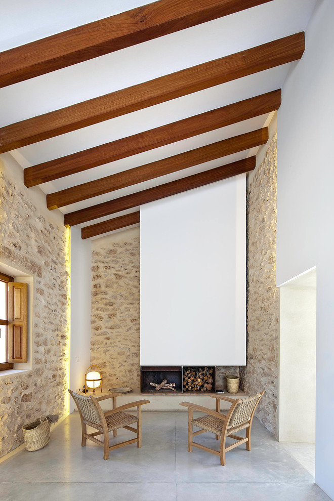 Mittelgroßes, Fernseherloses, Abgetrenntes Mediterranes Wohnzimmer mit Betonboden, Kamin, brauner Wandfarbe und Kaminumrandung aus Metall in Sonstige