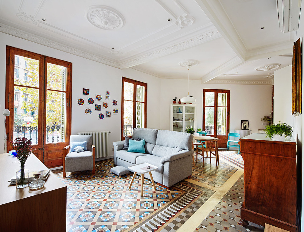 Modelo de sala de estar abierta mediterránea de tamaño medio sin chimenea y televisor con paredes blancas, suelo multicolor y suelo de baldosas de cerámica