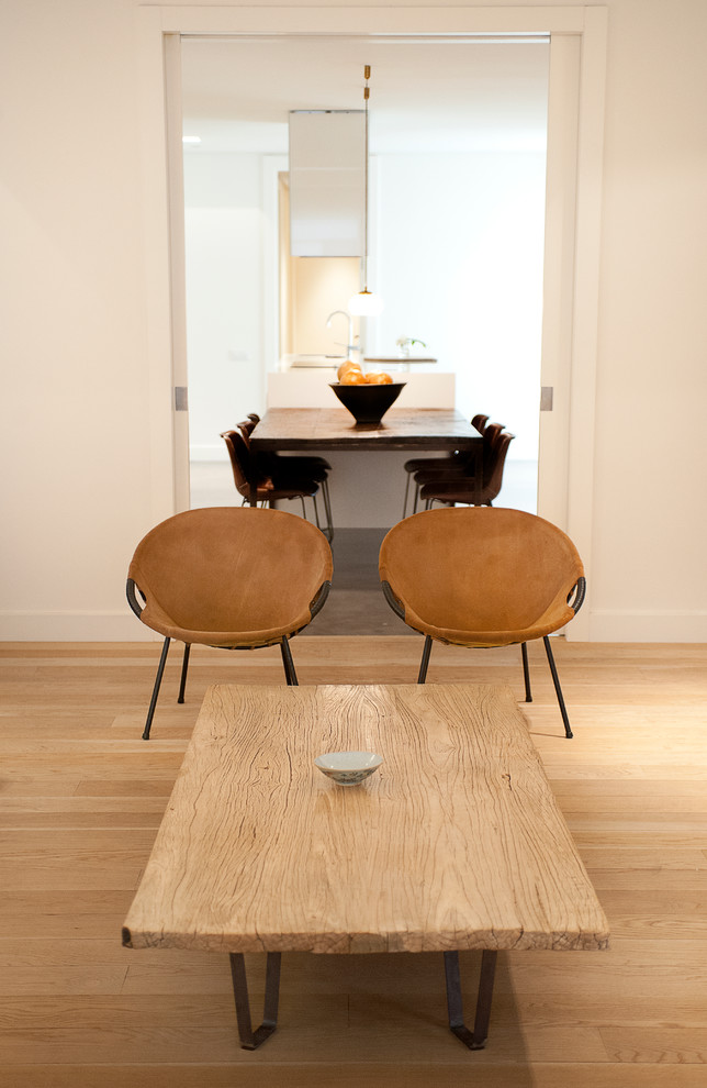 Modelo de sala de estar abierta actual de tamaño medio sin chimenea con paredes blancas y suelo de madera clara
