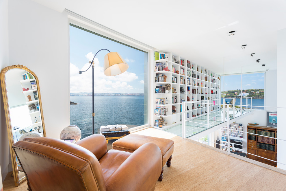 Idéer för mellanstora funkis allrum på loftet, med ett bibliotek, vita väggar och ljust trägolv