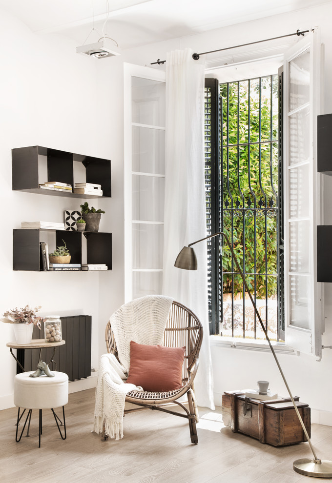 Imagen de sala de estar abierta escandinava de tamaño medio sin chimenea y televisor con paredes blancas y suelo de madera clara