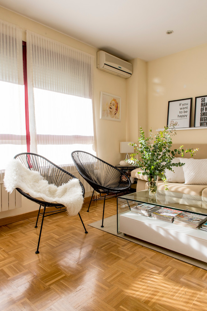Foto de sala de estar cerrada clásica renovada de tamaño medio sin chimenea con paredes amarillas y suelo de madera en tonos medios