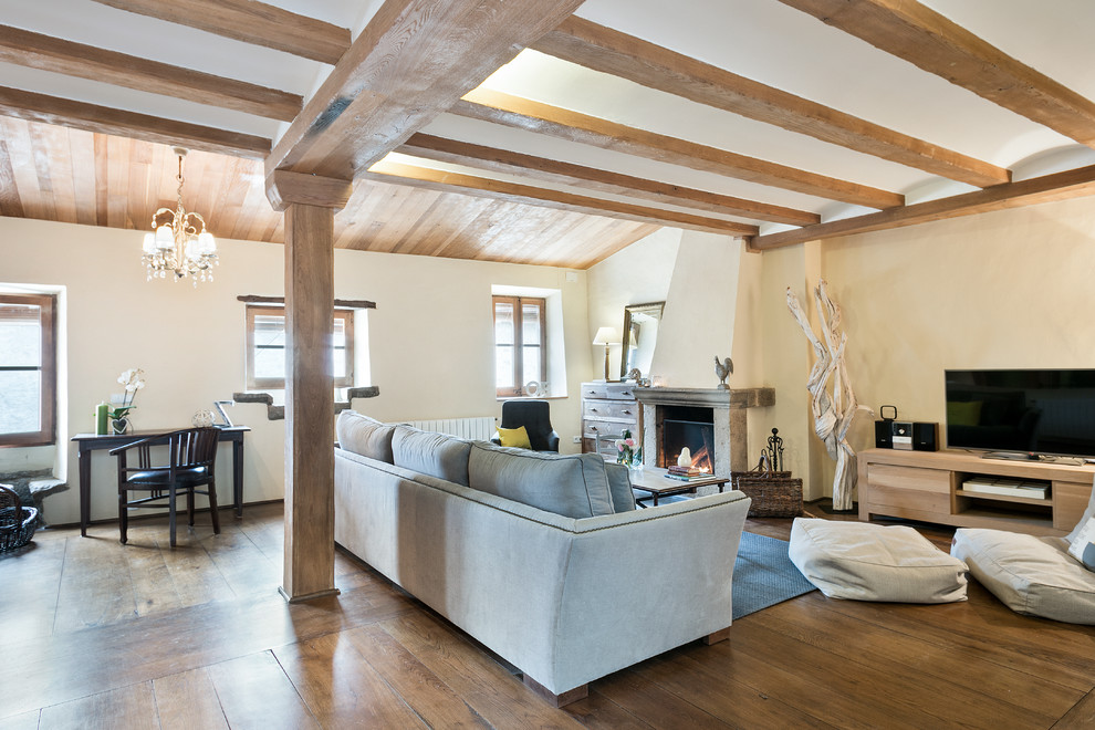 Inspiration for a medium sized farmhouse open plan games room in Barcelona with yellow walls, dark hardwood flooring, a standard fireplace, a stone fireplace surround and a built-in media unit.