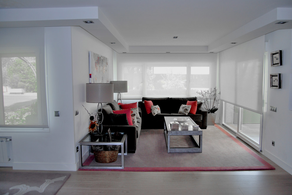 Großes, Fernseherloses, Offenes Stilmix Wohnzimmer mit weißer Wandfarbe, hellem Holzboden und braunem Boden in Madrid