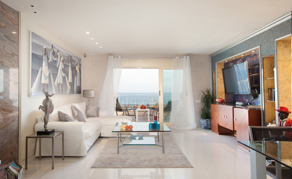 Modelo de sala de estar cerrada mediterránea grande sin chimenea con paredes beige, televisor colgado en la pared y suelo de baldosas de cerámica