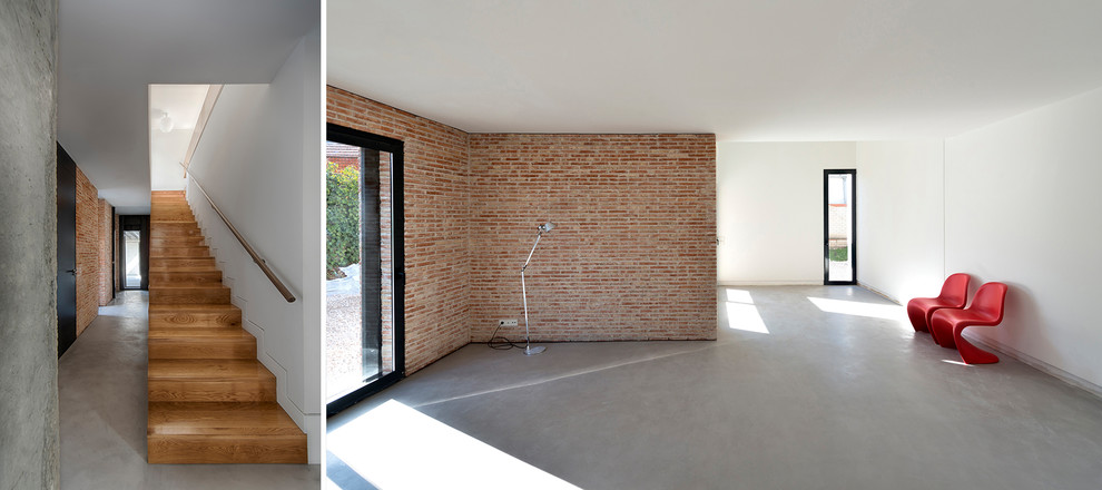 Imagen de sala de estar abierta contemporánea de tamaño medio con paredes blancas, suelo de cemento, chimeneas suspendidas, televisor independiente y suelo gris