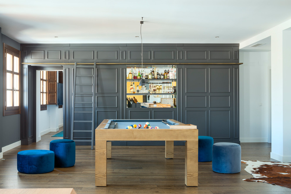Ejemplo de sala de juegos en casa actual grande con suelo de madera en tonos medios, suelo marrón y paredes grises