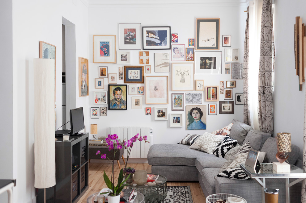 Diseño de sala de estar ecléctica pequeña sin chimenea con paredes blancas, suelo de madera en tonos medios, televisor independiente y suelo marrón