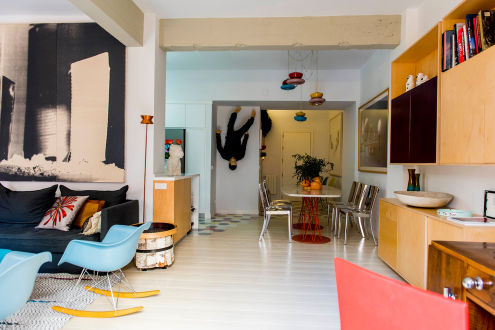 Modelo de sala de estar con biblioteca abierta bohemia de tamaño medio sin chimenea y televisor con paredes multicolor y suelo de madera clara
